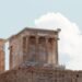 | GoCryptoBet.com Ancient stone temple ruins with tall columns and intricate carvings, set against a partly cloudy sky.